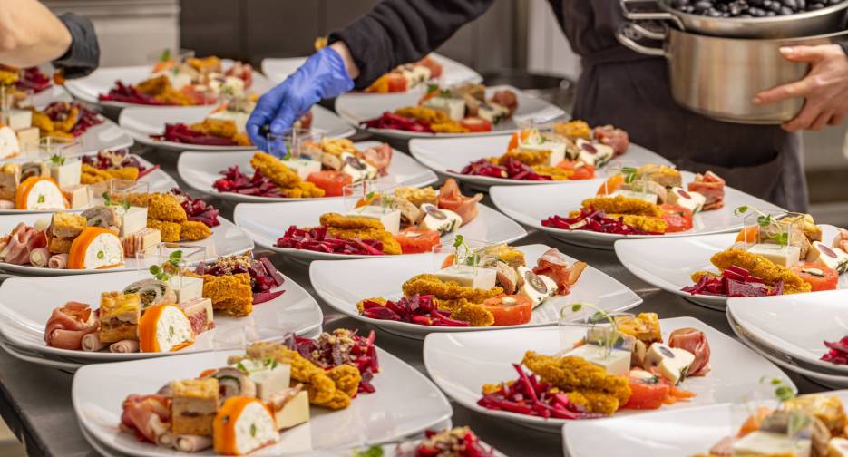 A chef arranging a plate of appetisers for wedding table